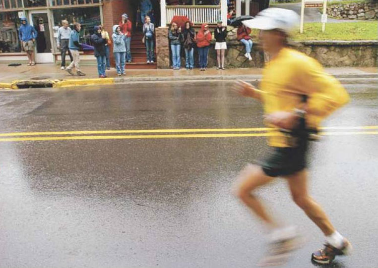 Spectators tried to stay dry under umbrellas and on porches Sunday as they cheered on runners during the Pikes Peak Marathon.