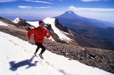 Matt Carpenter runs on Ixtacihuatl, a 17,343-foot volcano in Mexico, while Popocatepetl erupts in the background.