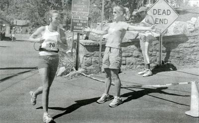 A volunteer for the 8th annual Barr Trail Mountain Race directs runners around the final bend of the course just 100 yards from the finish line.